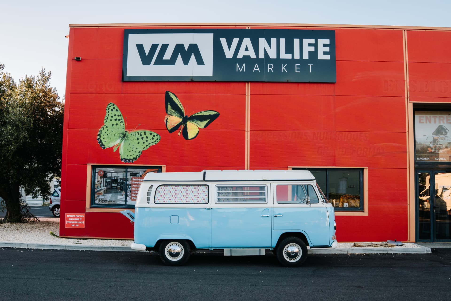 Volkswagen Combi T2 1970 — profil devant la façade Vanlife Market