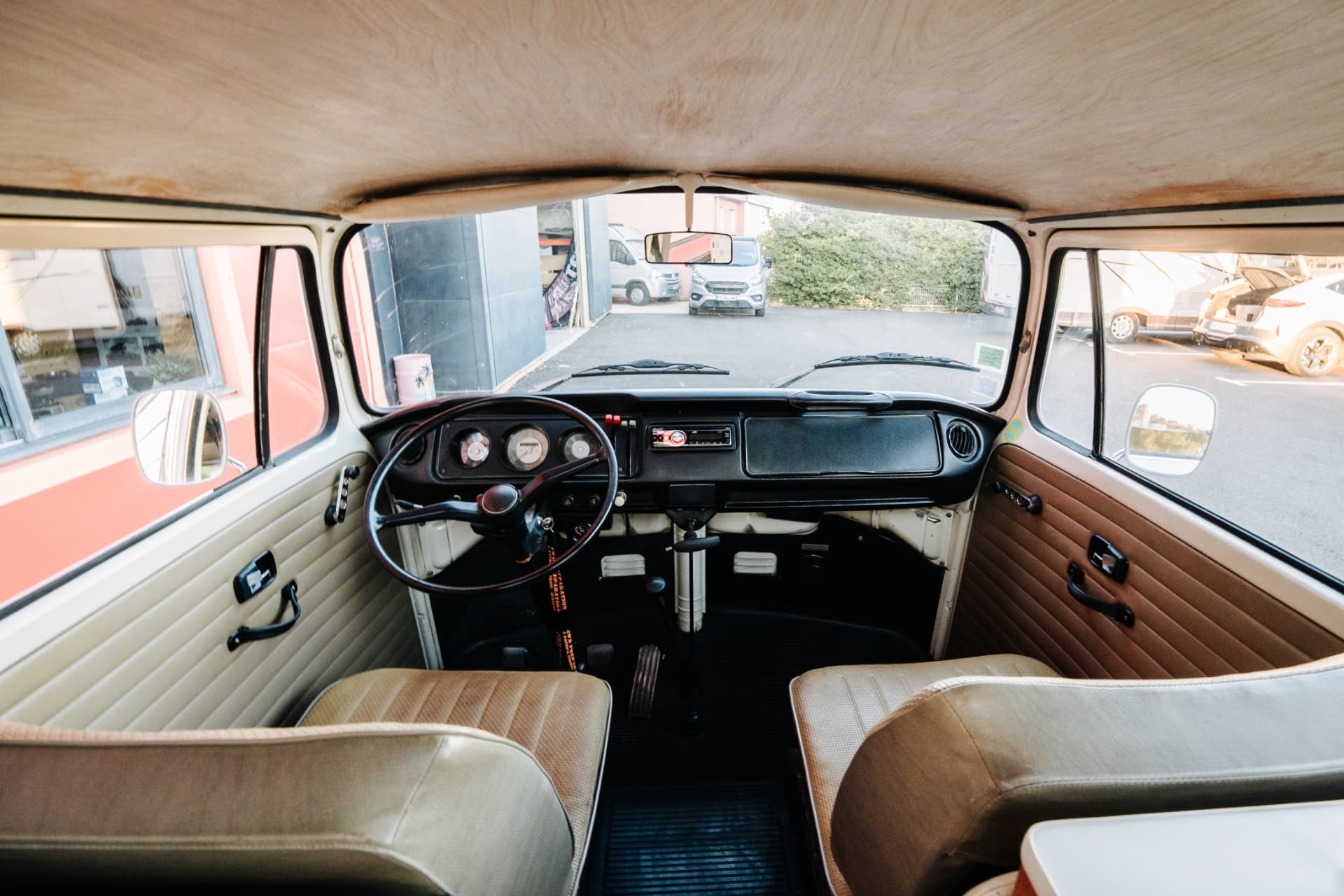 Volkswagen Combi T2 aménagé — sièges avant et cabine vus depuis l'habitacle
