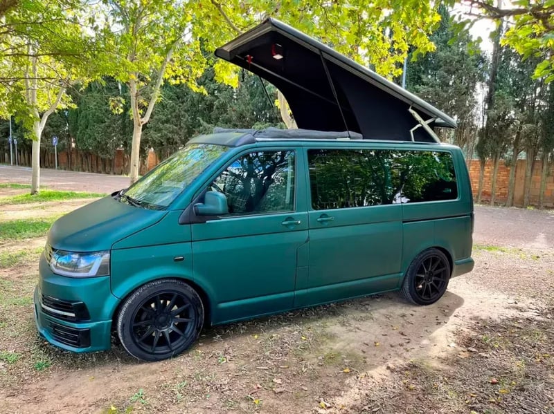 Toit relevable OVR ouvert sur un VW Transporter vert stationné en sous-bois