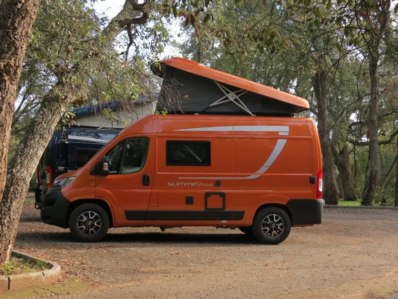 Toit relevable Sky-Up déployé sur un fourgon stationné sous les arbres